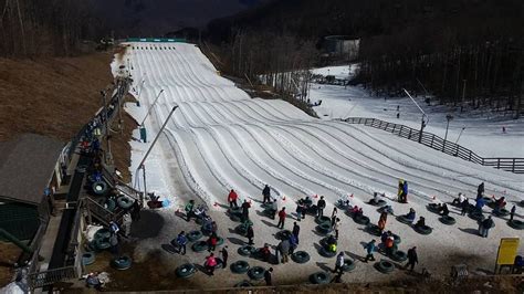 Snow tubing at The Plunge at Wintergreen Resort in Virginia; riders waiting for their turn Ski ...