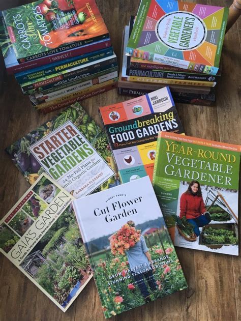 a pile of gardening books sitting on top of a wooden table next to each ...