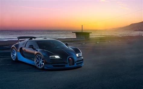 the bugatti veyron is parked in front of the ocean at sunset