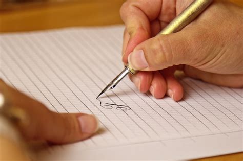 Premium Photo | Female hand writes with an ink pen on a white paper sheet with stripes.