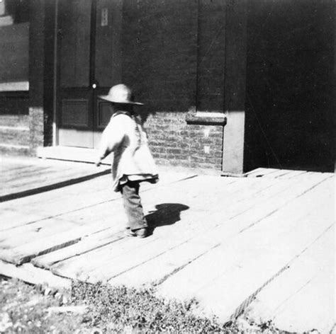Child walking on wooden sidewalk in front of stores / [Un … | Flickr