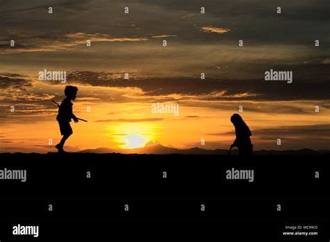 Silhouette of Children Playing on the beach at Sunset Stock Photo - Alamy