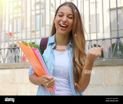 Excited student girl raising fist up outdoors Stock Photo - Alamy