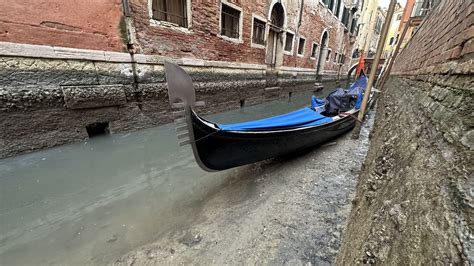 Photos show Venice’s canals running dry amid low tides