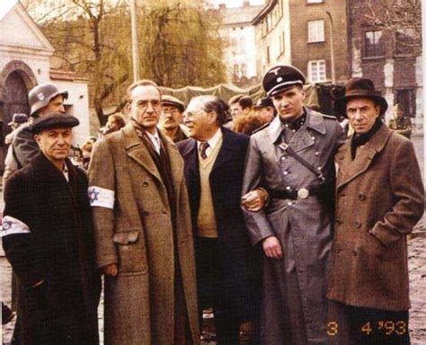 several men in coats and hats are standing next to each other on a cobblestone street