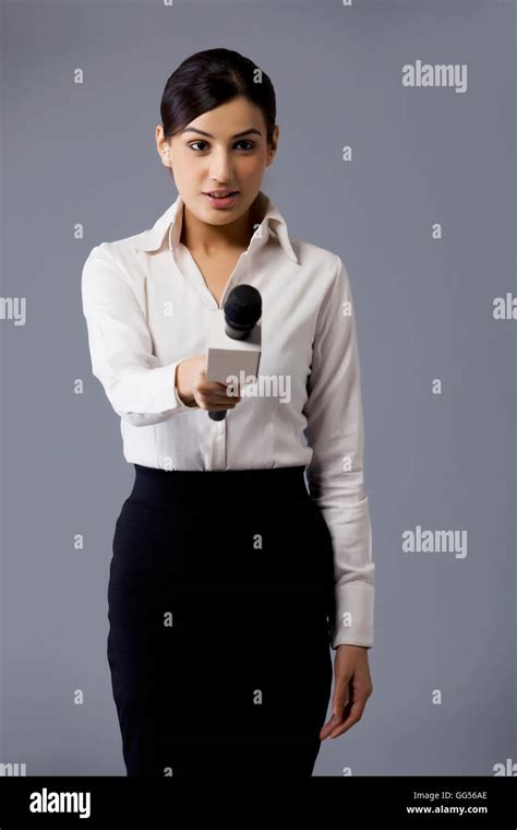 Portrait of well dressed TV reporter holding out microphone Stock Photo - Alamy