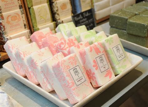 several different types of soaps sitting on a white platter in a store display