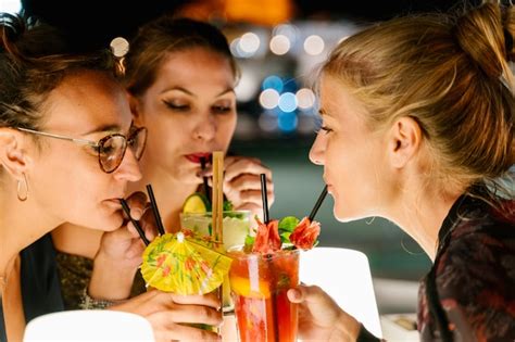 Premium Photo | Women drinking cocktails together on a terrace at night