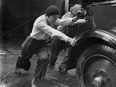 Woman pushing a broken-down car, 1930.