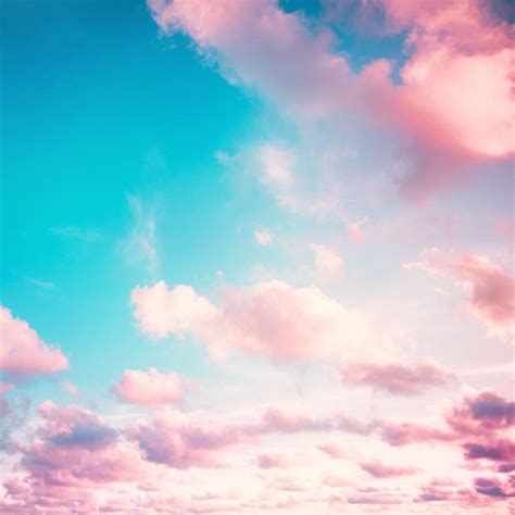 an airplane is flying in the sky with pink and blue clouds behind it on ...