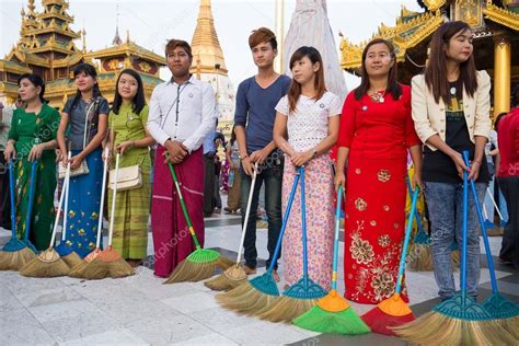 Burmese people participate in a ceremony with brooms at the Shwedagon Pagoda. Yangon, Myanmar ...