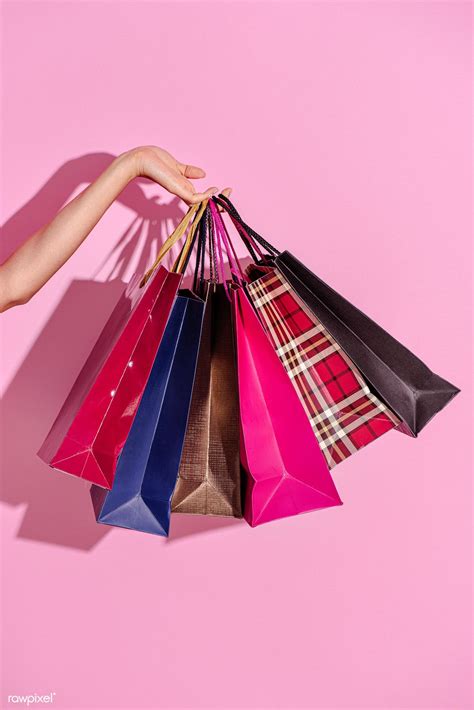 Woman carrying shopping bags against a pink background | premium image ...