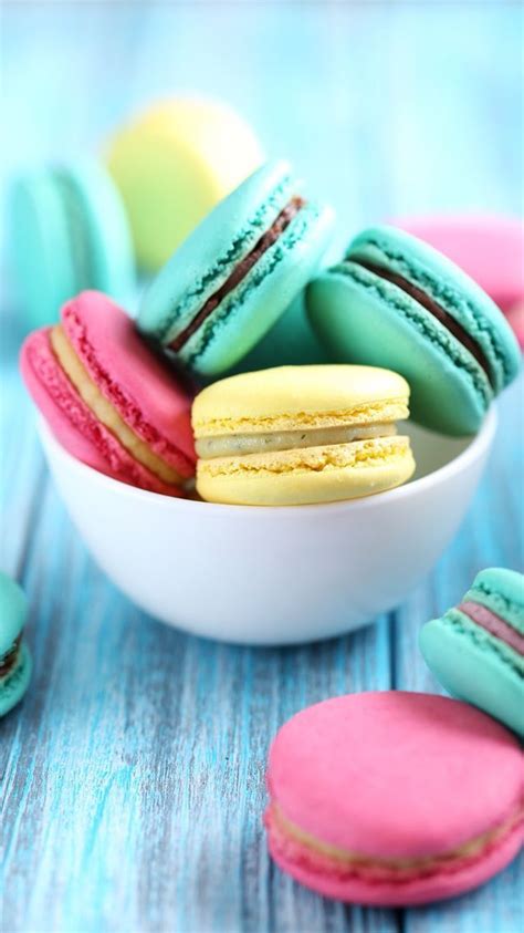 colorful macaroons in a white bowl on a blue table