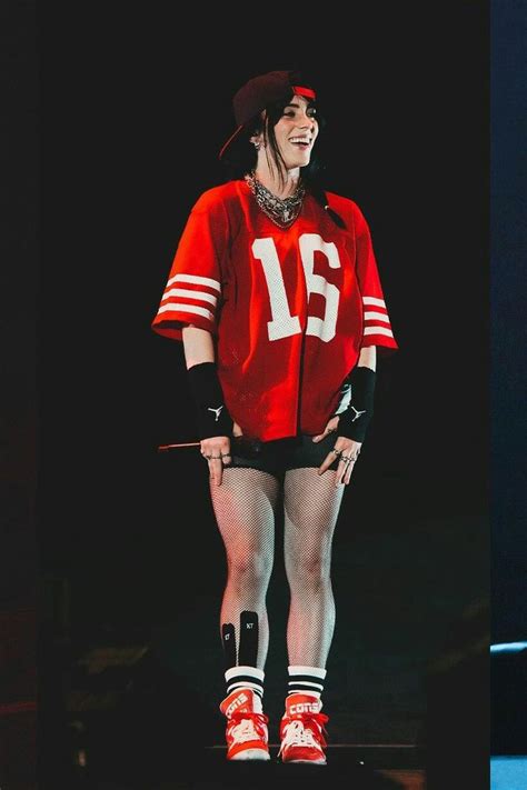 a woman in red and black outfit standing on stage