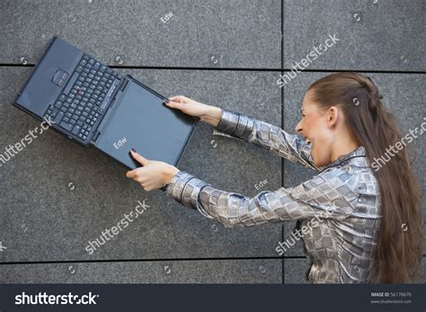 Angry Woman Smashing A Laptop Computer Against The Wall Stock Photo 56178670 : Shutterstock