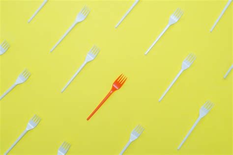 Premium Photo | Plastic forks on yellow background