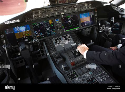 In glass cockpit of LCD screens, Boeing pilot with hands on throttles ...