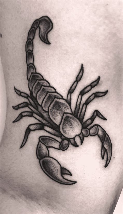 a black and white scorpion tattoo on the stomach