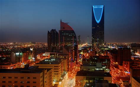 an aerial view of a city at night with tall buildings and street lights ...