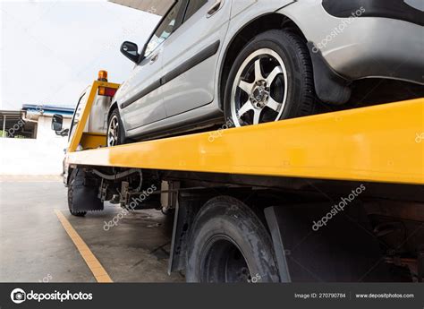 Broken car on flatbed tow truck being transported for repair Stock ...