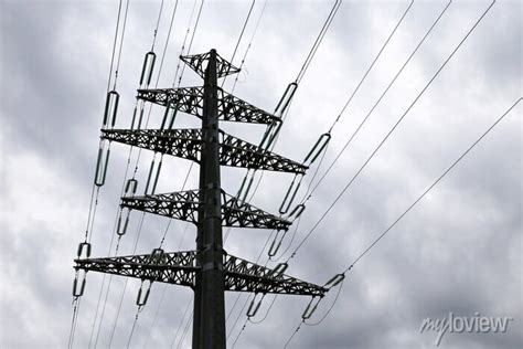 High voltage tower silhouette with electrical wires on storm posters ...