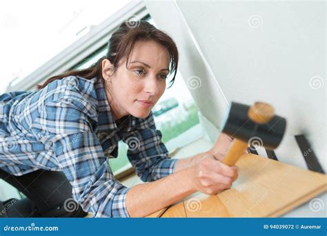 Beautiful Girl Using Hammer To Fit Wooden Floor Stock Photo - Image of woman, floor: 94039072