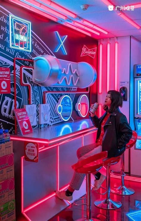a woman sitting at a bar with neon lights