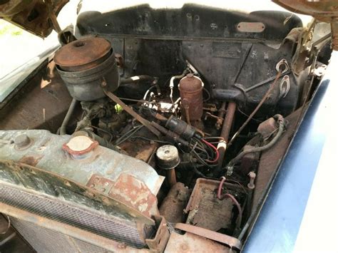 the engine compartment of an old car with rust