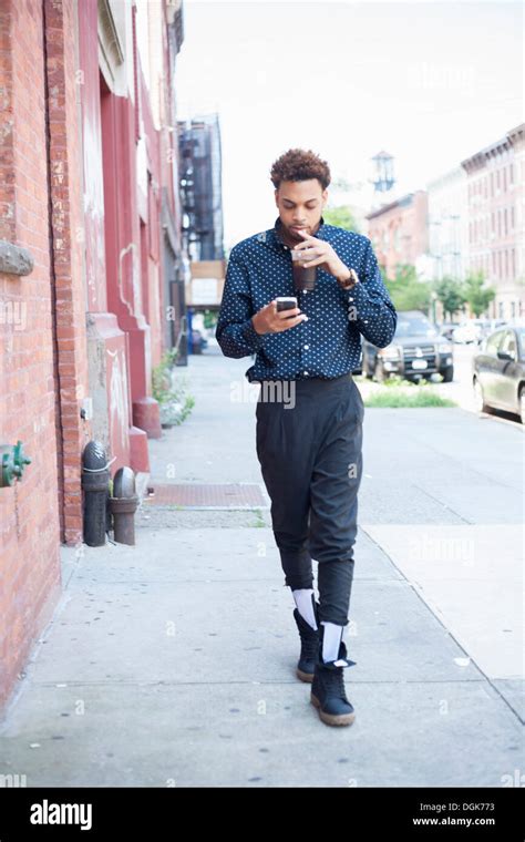 Young man walking down street with cellphone and drink Stock Photo: 61888375 - Alamy