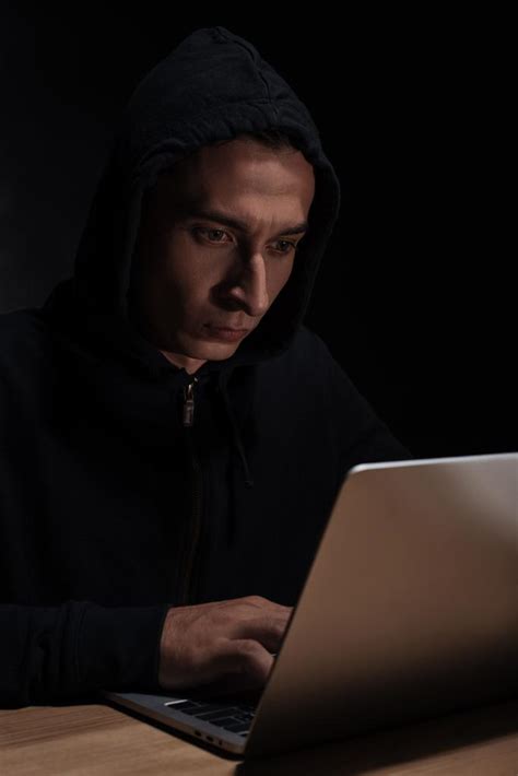 Hacker in black hoodie using laptop, cuber security concept Free Stock ...