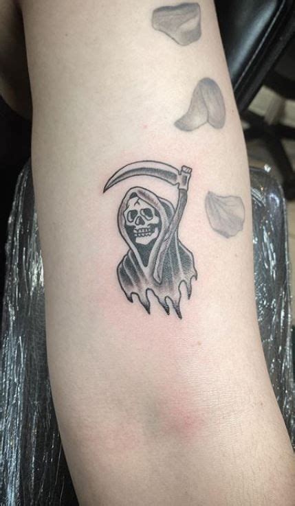 a person with a tattoo on their arm holding a knife and wearing a skull mask