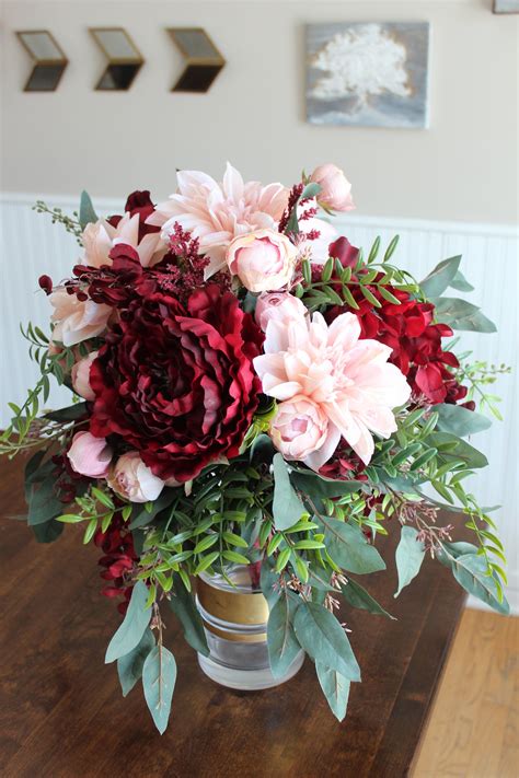 a vase filled with flowers on top of a wooden table