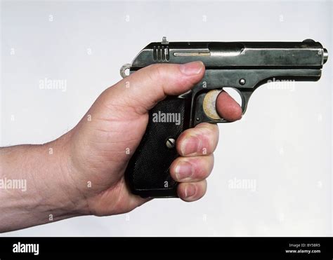 A man holding a gun, side view, hand only Stock Photo - Alamy