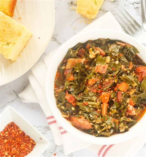 a bowl of southern collard greens served with cornbread with red pepper ...