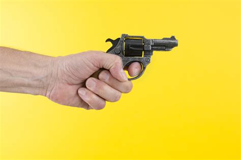 Mans Hand Holding Revolver On A Yellow Background Stock Photo - Download Image Now - Aiming, Arm ...