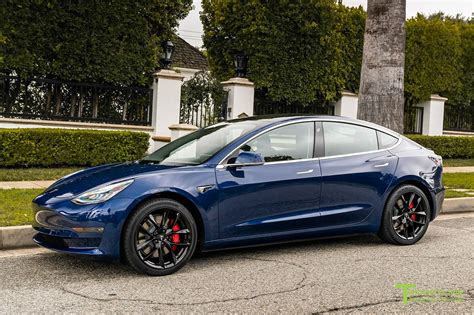 a blue tesla parked on the side of the road