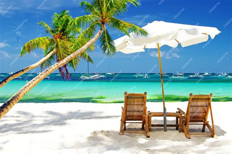 Premium Photo | Exotic tropical beach scenery. beach chairs under palm trees