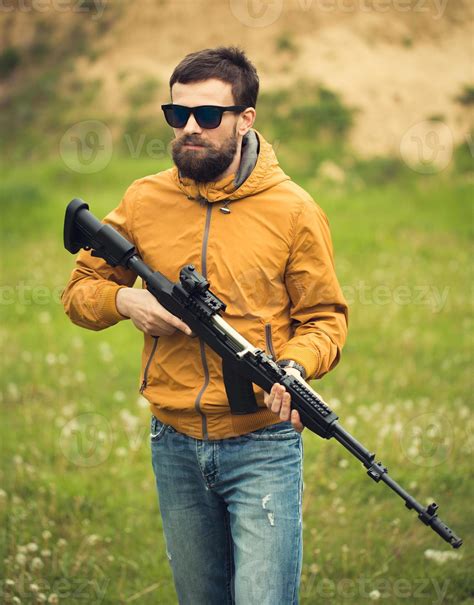 A man with an automatic rifle 21046376 Stock Photo at Vecteezy