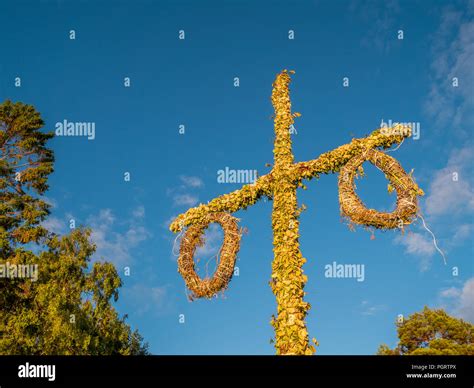 Swedish maypole used on midsummer or midsommar in sun set light. Blue sky in background Stock ...