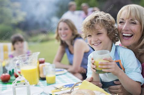 Family eating together outdoors - Stock Image - F014/2677 - Science Photo Library