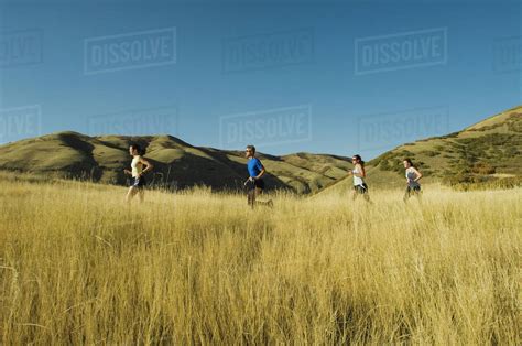 Group of people running in field, Utah, United States - Stock Photo ...