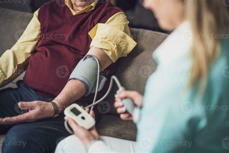 Elderly man with female caretaker at home. Health concept. 23572732 Stock Photo at Vecteezy