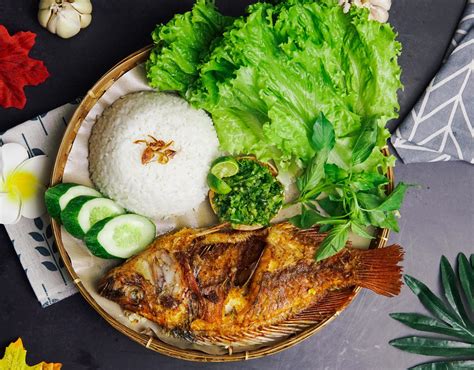 a package of rice, fried fish and some fresh vegetables on a black background 4886086 Stock ...