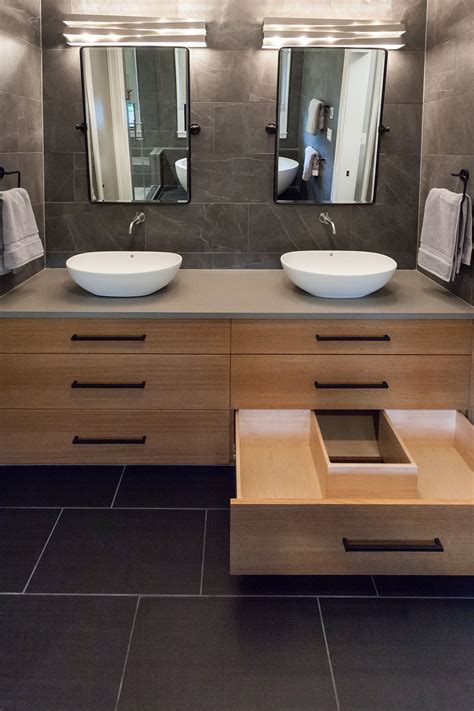 Full tiled master bathroom featuring floating vanity with vessel sinks ...