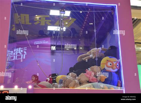 Players grab dolls inside a two-storey human doll-grabbing machine ...