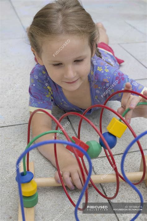 Little girl playing with colorful wooden toy — watching, skill - Stock Photo | #181846416