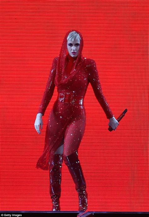 a woman dressed in red is walking on stage with a knife and wearing ...