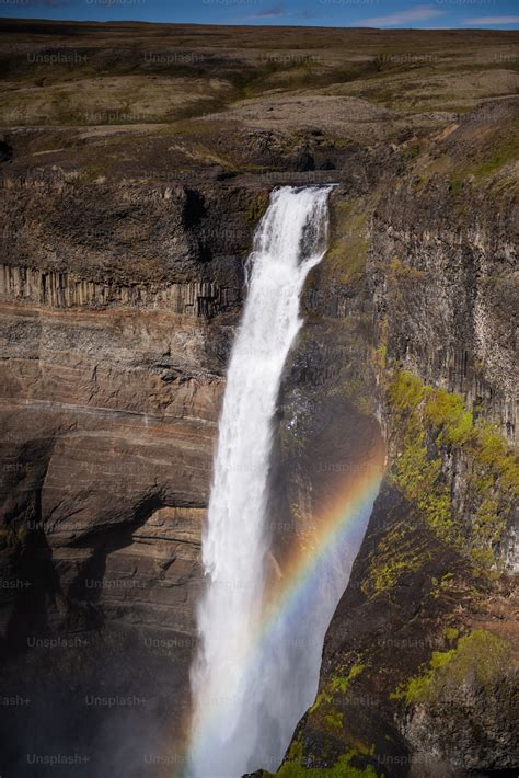 A waterfall in a canyon photo – Mountains Image on Unsplash