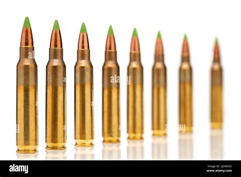 A group of 5.56 calibar, green tip bullets on white background Stock Photo - Alamy