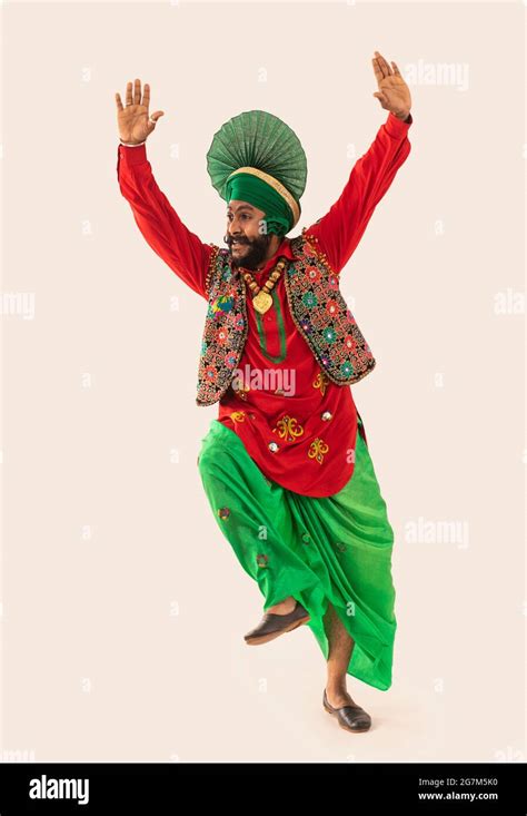 A Bhangra dancer performing a dance step with hands in the air Stock ...